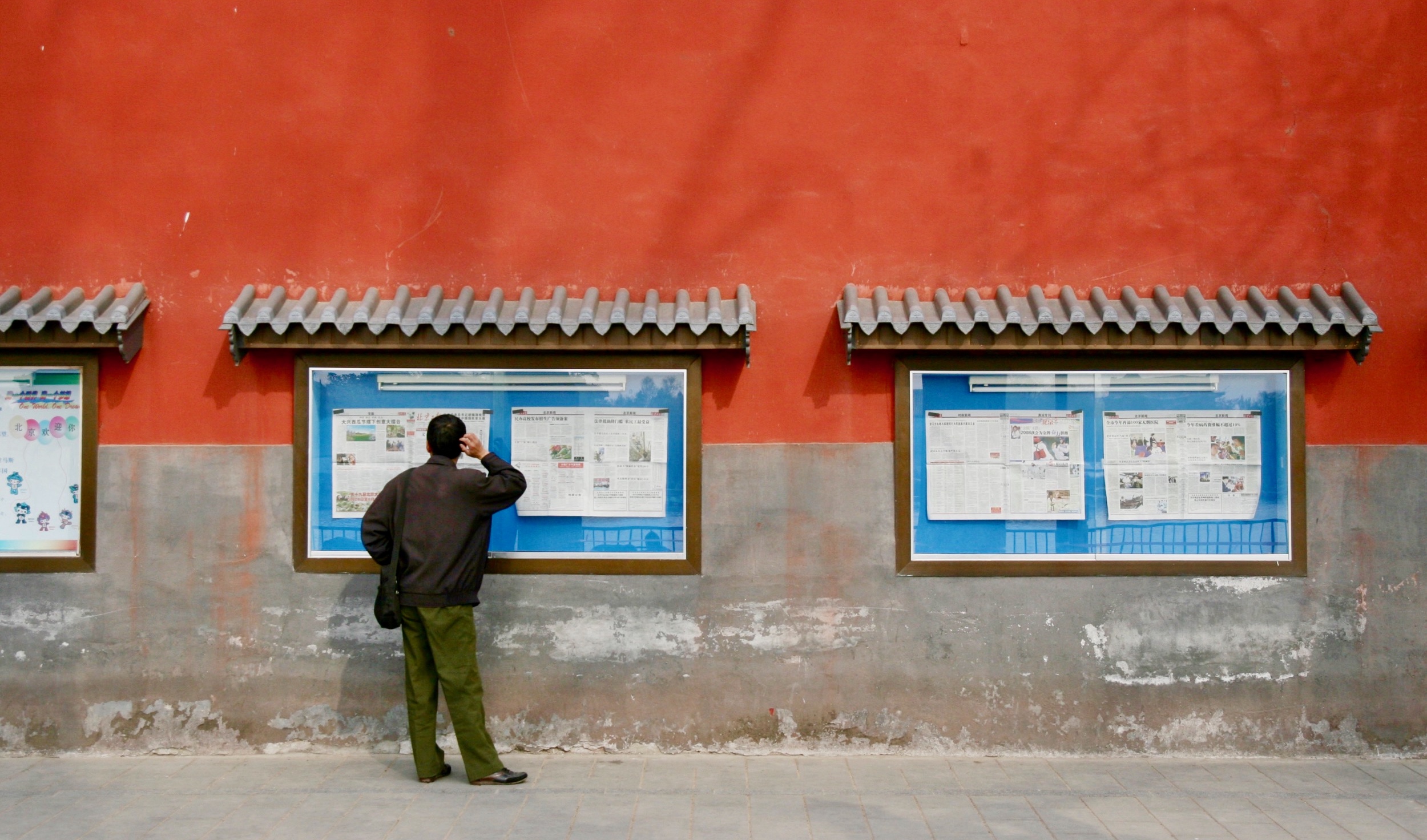 Photographie d’illustration: Un homme consulte les journaux affichés au mur